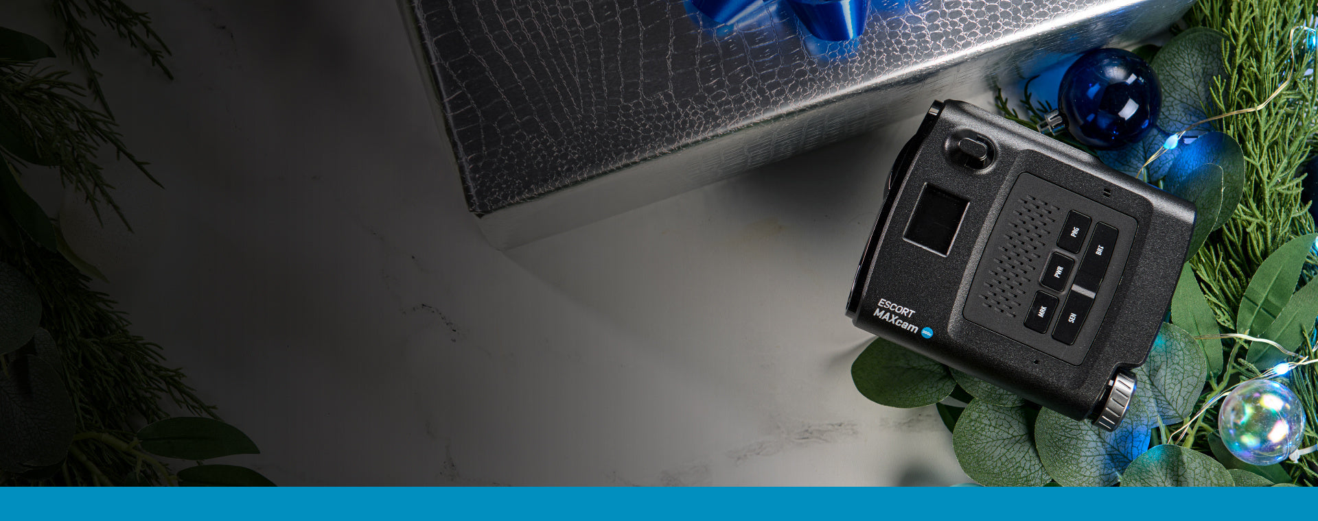 Escort MAXcam 360c next to gift box and holiday ornaments